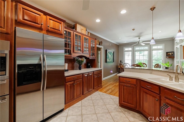 kitchen featuring ceiling fan, sink, light tile patterned floors, decorative light fixtures, and built in fridge