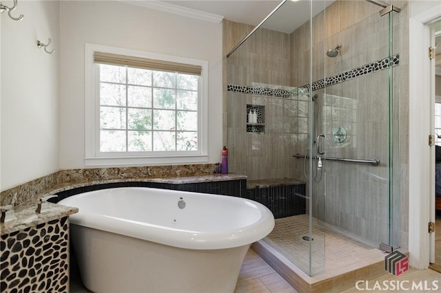 bathroom with shower with separate bathtub and ornamental molding