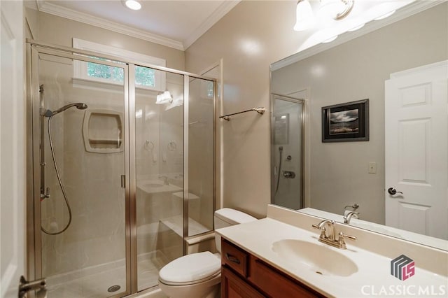 bathroom featuring vanity, toilet, a shower with shower door, and crown molding