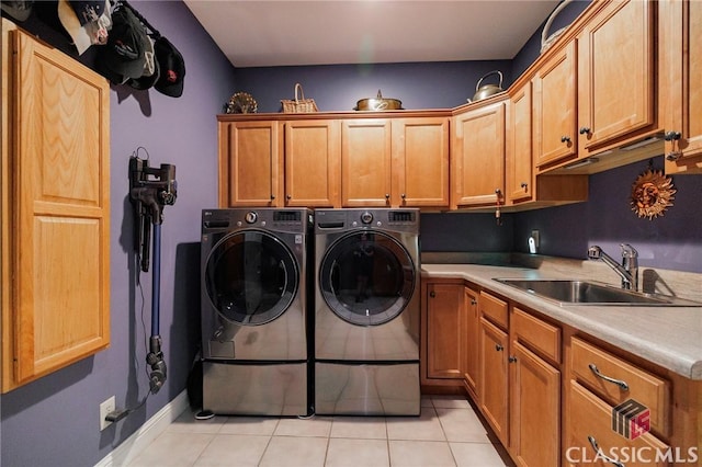 laundry area featuring separate washer and dryer, sink, light tile patterned floors, and cabinets