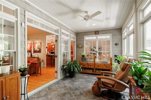 sunroom with ceiling fan and wooden ceiling