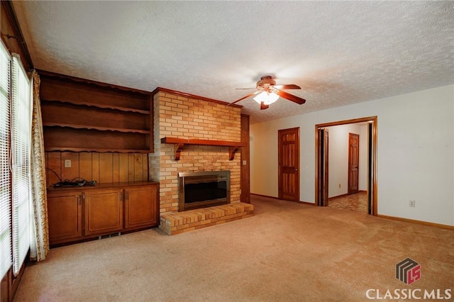 unfurnished living room featuring a fireplace, ceiling fan, plenty of natural light, and a textured ceiling