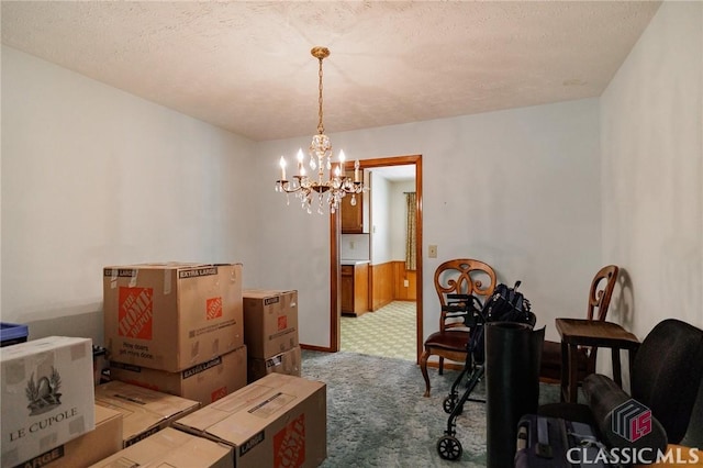 dining room featuring carpet, a textured ceiling, and a chandelier