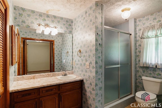 bathroom featuring vanity, a textured ceiling, toilet, and walk in shower