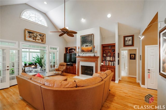 living room featuring a wealth of natural light, french doors, and light wood-type flooring