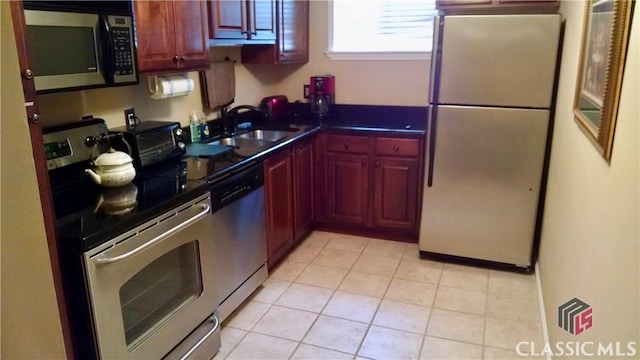 kitchen featuring sink, light tile patterned floors, and stainless steel appliances