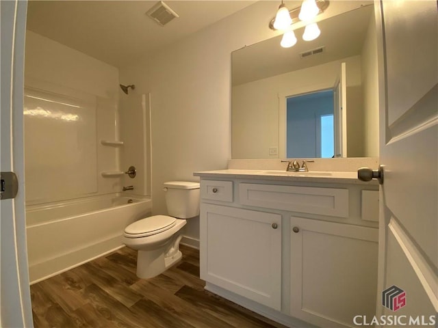 full bathroom with vanity, toilet, washtub / shower combination, and hardwood / wood-style flooring