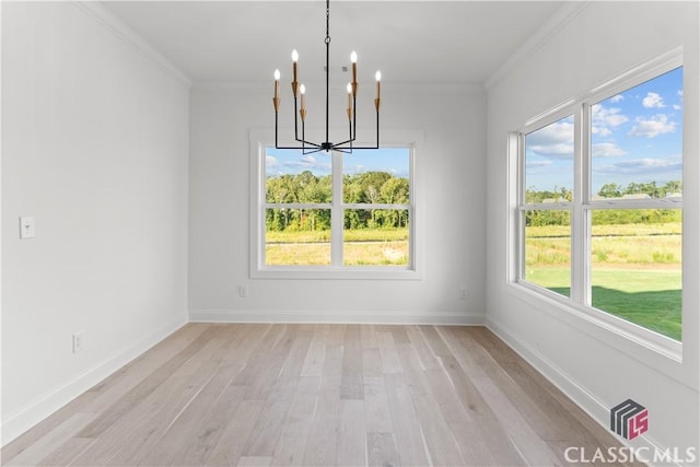 unfurnished dining area with light hardwood / wood-style flooring, an inviting chandelier, and ornamental molding