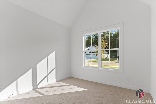 carpeted spare room with high vaulted ceiling