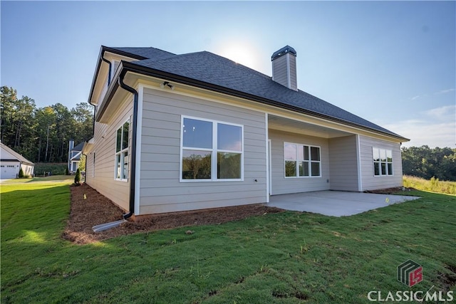 rear view of property with a patio and a lawn