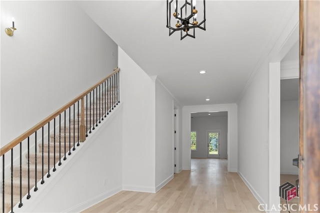 interior space with light hardwood / wood-style floors, crown molding, and a chandelier