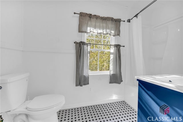 bathroom featuring tile patterned flooring, vanity, toilet, and curtained shower