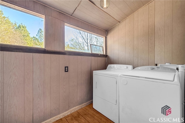 laundry area featuring wood ceiling, light hardwood / wood-style floors, independent washer and dryer, and wooden walls