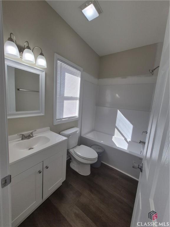 full bathroom featuring shower / tub combination, toilet, vanity, and hardwood / wood-style flooring