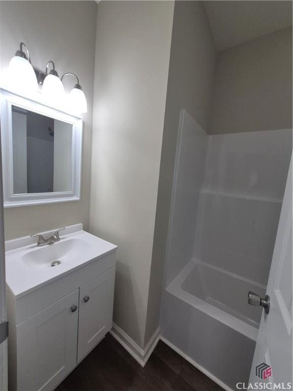 bathroom featuring vanity, hardwood / wood-style flooring, and shower / bathtub combination