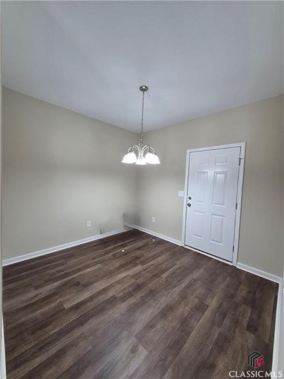 unfurnished dining area featuring dark hardwood / wood-style floors and a chandelier