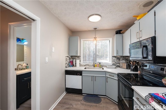 kitchen featuring decorative light fixtures, backsplash, a textured ceiling, and black appliances