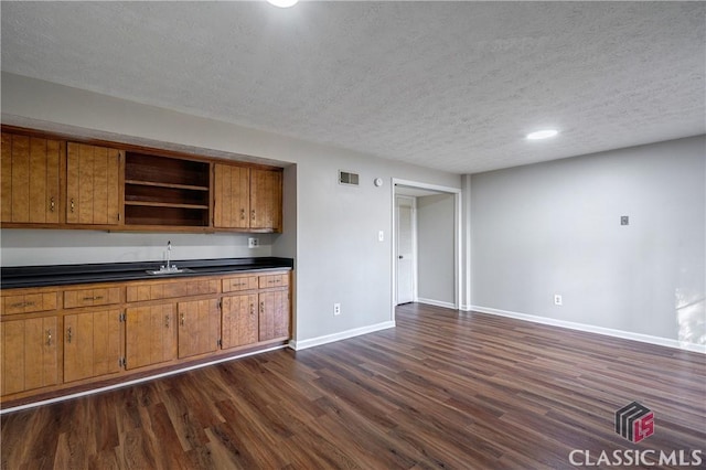 kitchen with sink, dark hardwood / wood-style flooring, and a textured ceiling