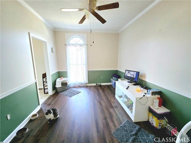 interior space with a textured ceiling, ceiling fan, wood finished floors, and crown molding