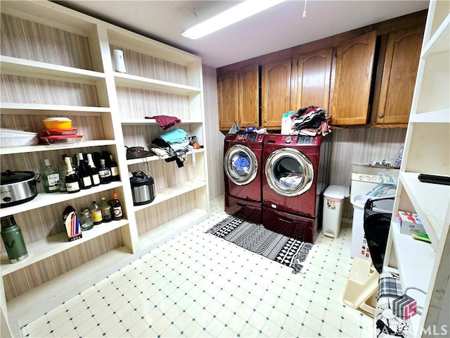 laundry room featuring light floors, washing machine and dryer, and cabinet space