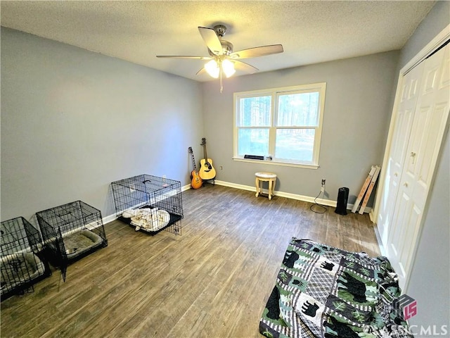 interior space featuring a textured ceiling, baseboards, and wood finished floors