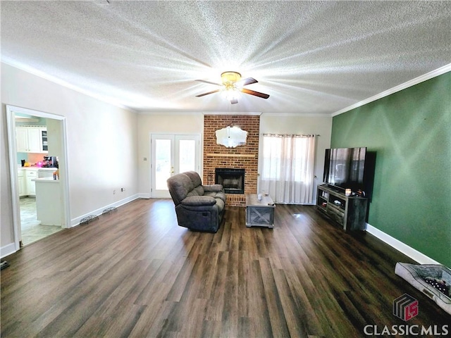 living room with a healthy amount of sunlight, a brick fireplace, ornamental molding, and dark wood-type flooring