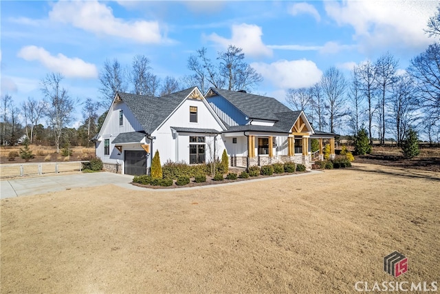 view of front of property featuring a porch, a front lawn, and a garage