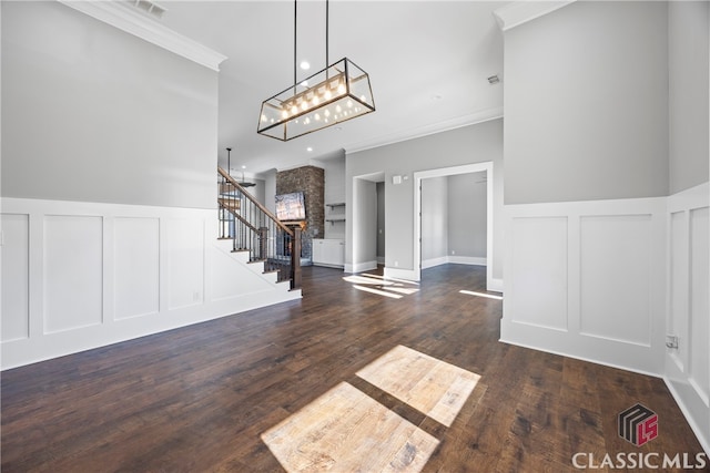 entryway with ornamental molding, dark wood-type flooring, and a notable chandelier