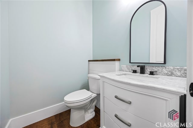 bathroom featuring toilet, vanity, and hardwood / wood-style floors