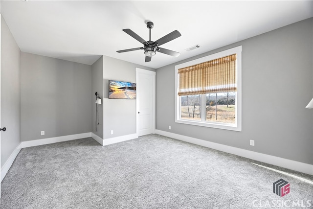 empty room featuring ceiling fan and light carpet