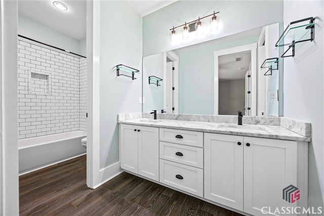 full bathroom featuring tiled shower / bath combo, toilet, vanity, and hardwood / wood-style flooring