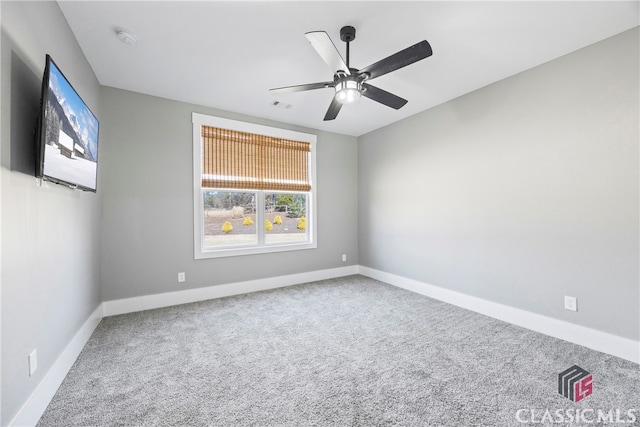 carpeted spare room with ceiling fan