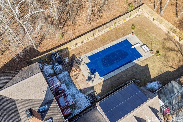 rear view of property featuring a covered pool and a patio area