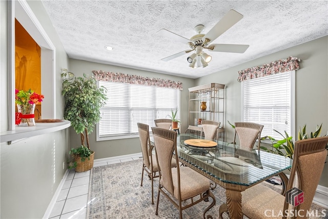 dining room with light tile patterned flooring, a textured ceiling, ceiling fan, and plenty of natural light