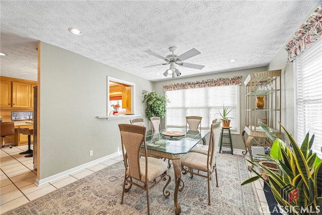 tiled dining area with ceiling fan, a textured ceiling, and plenty of natural light