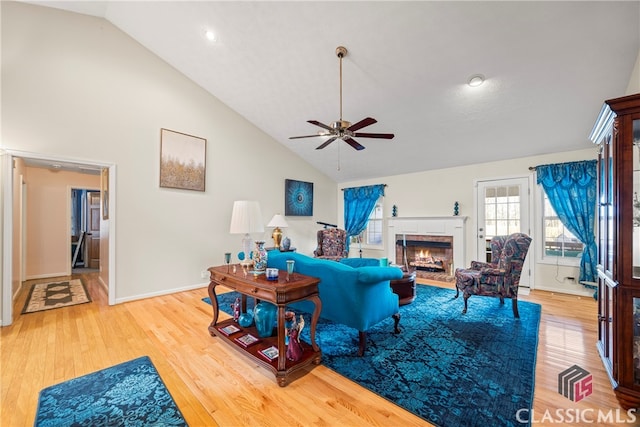 living room with wood-type flooring, ceiling fan, and vaulted ceiling