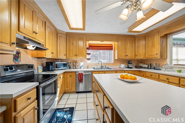 kitchen featuring stainless steel appliances, ceiling fan, light tile patterned floors, and sink