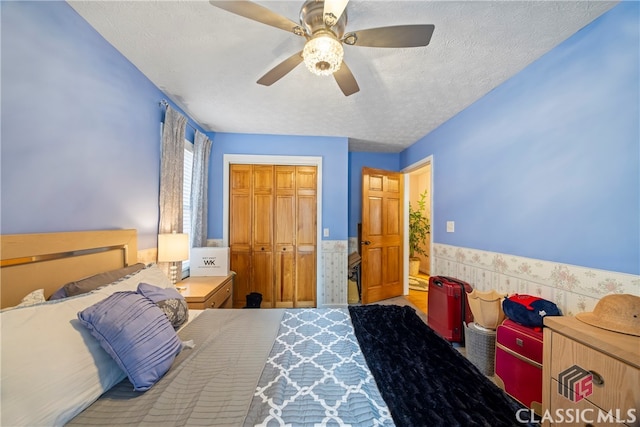 bedroom featuring a textured ceiling, ceiling fan, and a closet