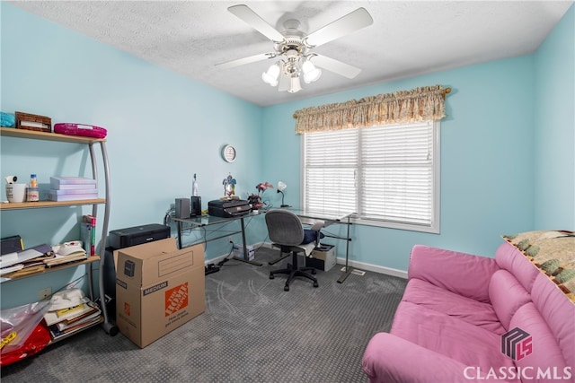 office area featuring ceiling fan, a textured ceiling, and dark carpet