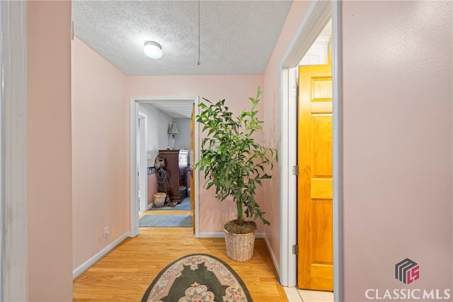 hallway featuring a textured ceiling and light wood-type flooring