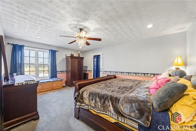 bedroom featuring a textured ceiling, ceiling fan, and carpet