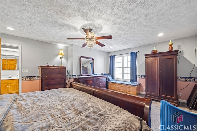 bedroom featuring ensuite bathroom, a textured ceiling, and ceiling fan