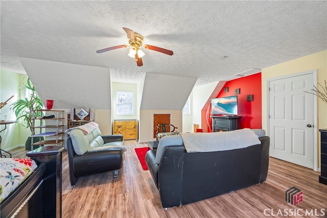 living room with ceiling fan, a textured ceiling, and hardwood / wood-style flooring