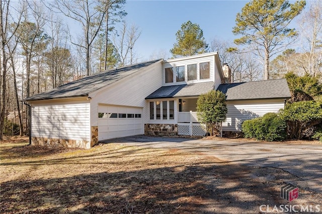 front of property featuring covered porch and a garage