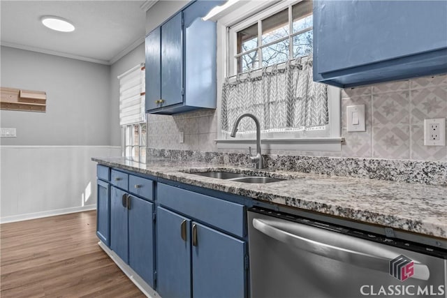 kitchen featuring dishwasher, backsplash, blue cabinets, ornamental molding, and sink