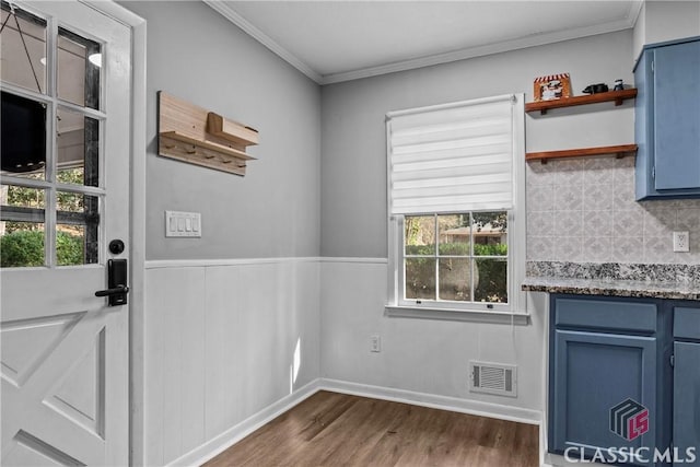 doorway featuring dark wood-type flooring, crown molding, and a healthy amount of sunlight