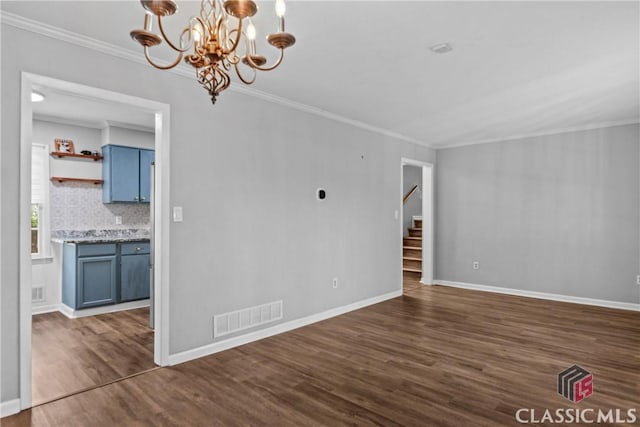 unfurnished room with dark hardwood / wood-style flooring, ornamental molding, and a notable chandelier