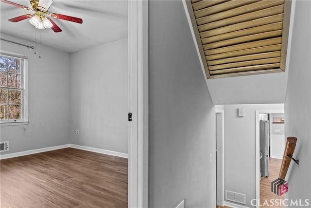 stairs with wood-type flooring, ceiling fan, and vaulted ceiling