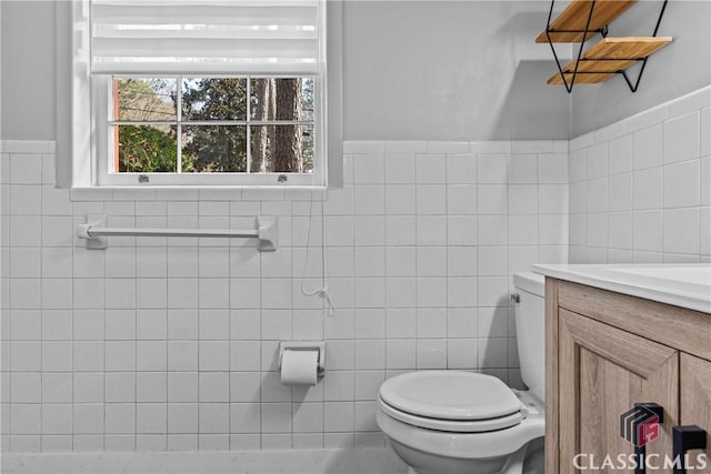 bathroom with tile walls, vanity, and toilet