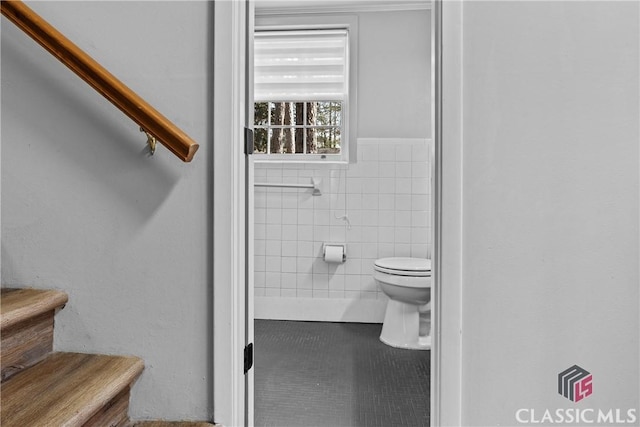 bathroom with tile walls, tile patterned flooring, and toilet